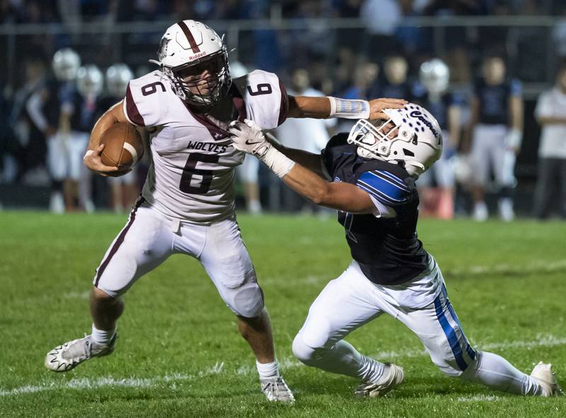 Prairie Ridge quarterback Luke Vanderwiel holds off a tackle from Burlington Central's Trevor Raap during their game on Friday, September 19, 2025 at Burlington Central High School. Ryan Rayburn for Shaw Local