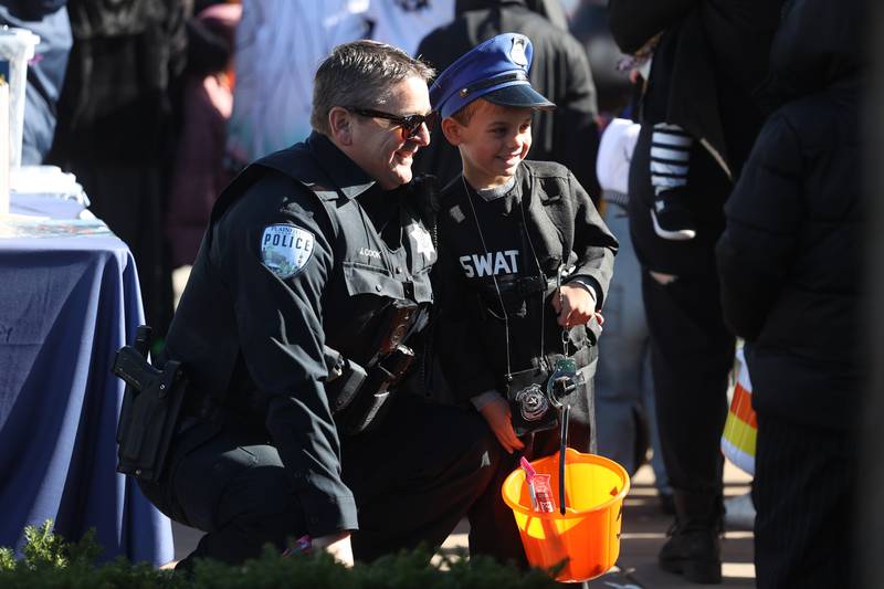 Theodore Shanahan, 5-years old, gets his photo takes with Plainfield Police Officer Cook at the annual Halloween Spooktacular in downtown Plainfield on Saturday, Oct. 28, 2023.