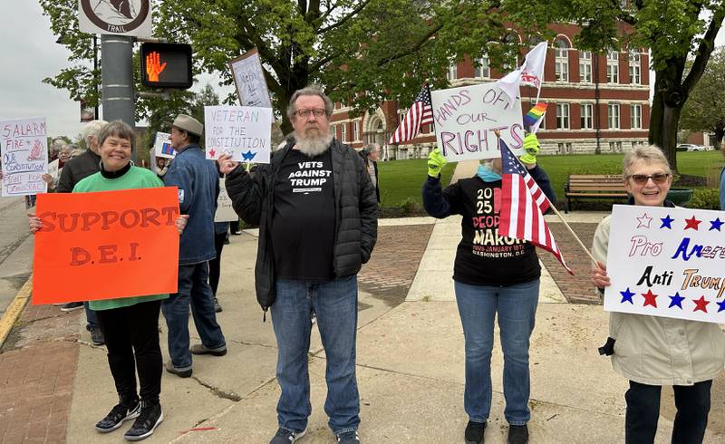 Attendees held signs at the May Day Rally on Thursday, May 1, 2025 in Oregon. The evening event was held around the historic Ogle County Courthouse.