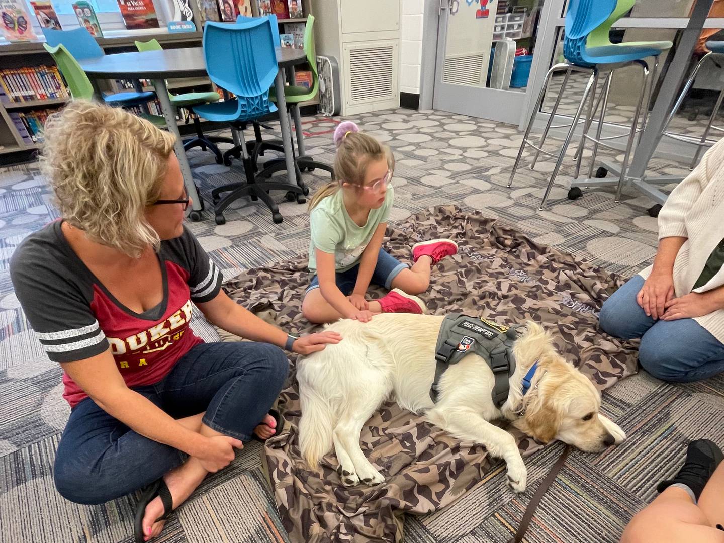 Emily Schilf, McHenry's Learning Center Director, sits with student Brynn Kline and Oakley, the McHenry Police Department's therapy dog. Shilf died last week at age 42.