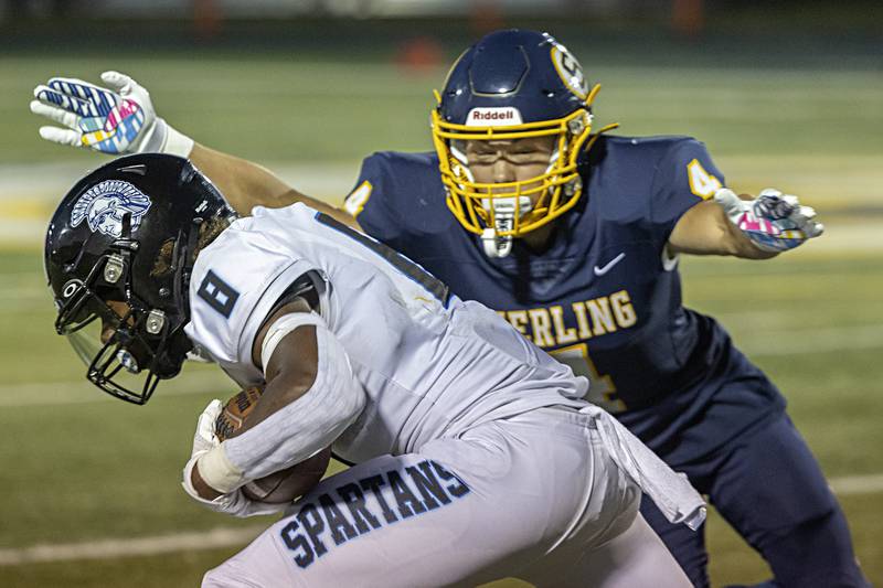 St. Francis’ TyVonn Ransom fights for yards as Sterling’s Isaiah Mendoza goes in for the tackle Friday, Sept. 1, 2023 at Sterling High School.