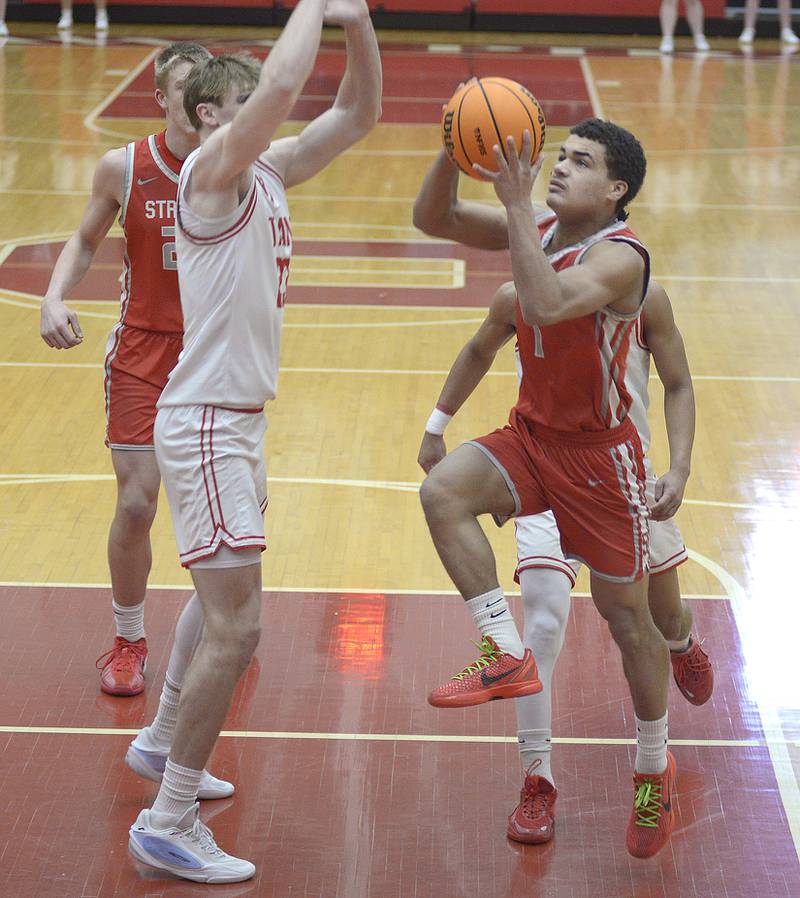 Streator’s Layzeric Moton works to go up and around Ottawa’s Owen Sanders for a layup in the 1st period Saturday at Ottawa.