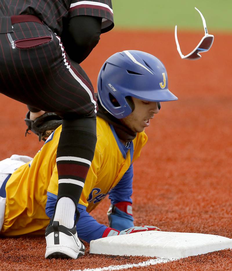 Johnsburg's Dom Vallone dives back safely to first base San Marengo's Brady Kentgen’s sunglasses go flying during a Kishwaukee River Conference baseball game on Monday, April 21, 2025, at Johnsburg High School.