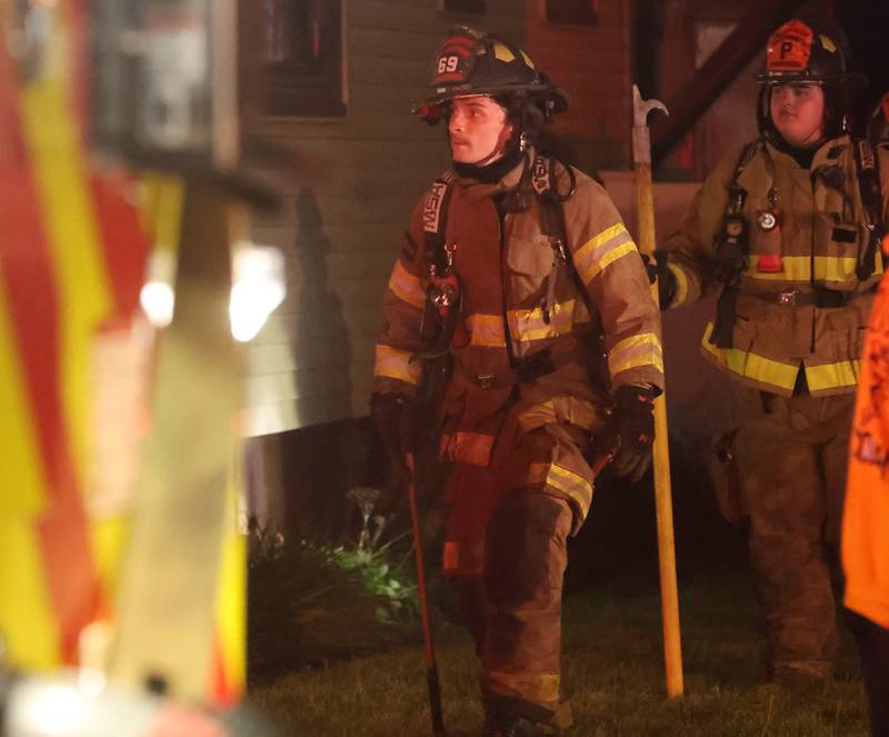 Spring Valley firefighters walk around the front of a home in the 500 block of West Erie Street for a structure fire on Monday, May 4, 2026 in Spring Valley. The fire happened shortly before 10:45p.m. A Mutual Aid Box Alarm System (MABAS) call was dispatched for additional fire departments from Eastern Bureau County, Peru, Utica, Oglesby and La Salle.