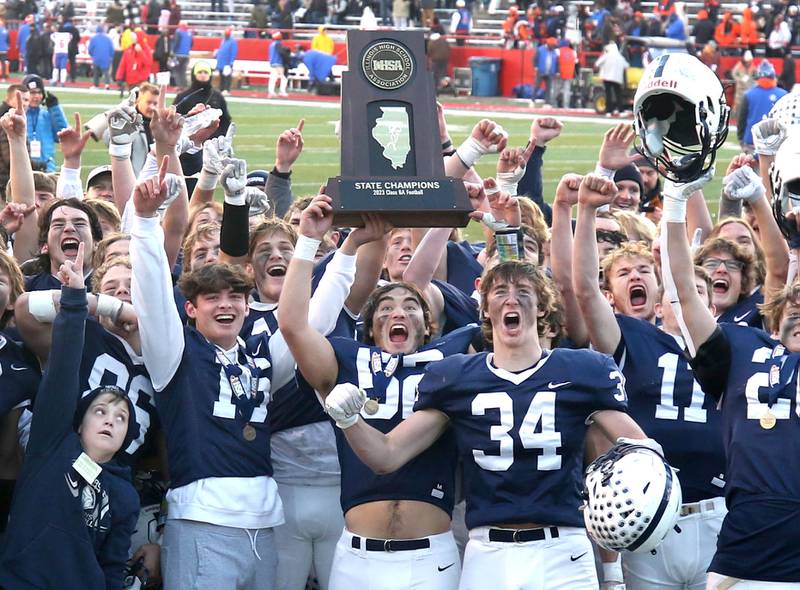 Cary-Grove players celebrate with the trophy Saturday, Nov. 25, 2023, after their win over East St. Louis in the IHSA Class 6A state championship game in Hancock Stadium at Illinois State University in Normal.