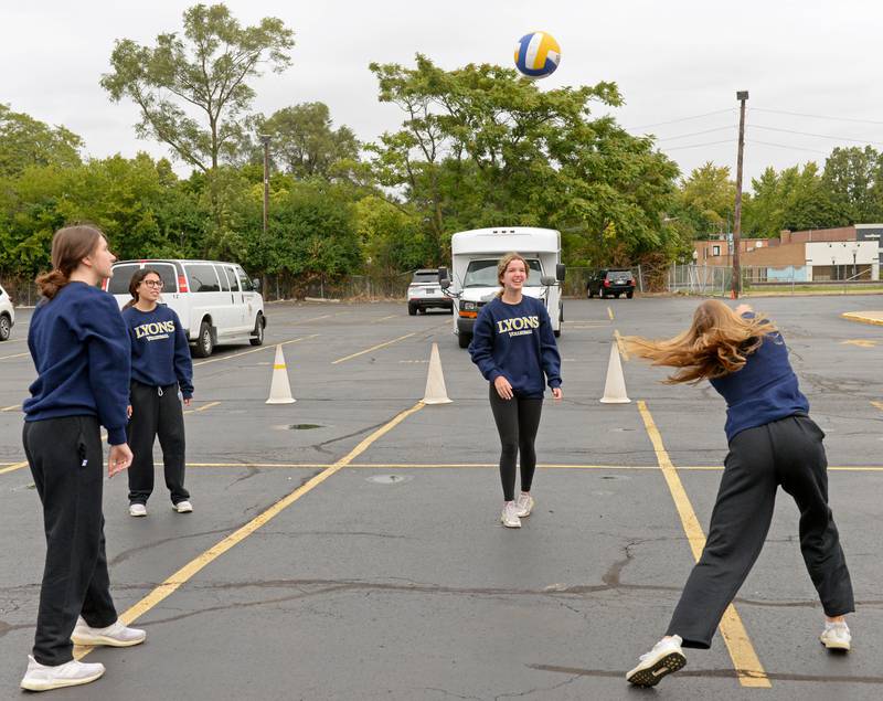 Lyons Township High School volleyball players get warmed up in the north campus parking lot while waiting for the annual homecoming parade to begin on Saturday, Sept. 24, 2022.