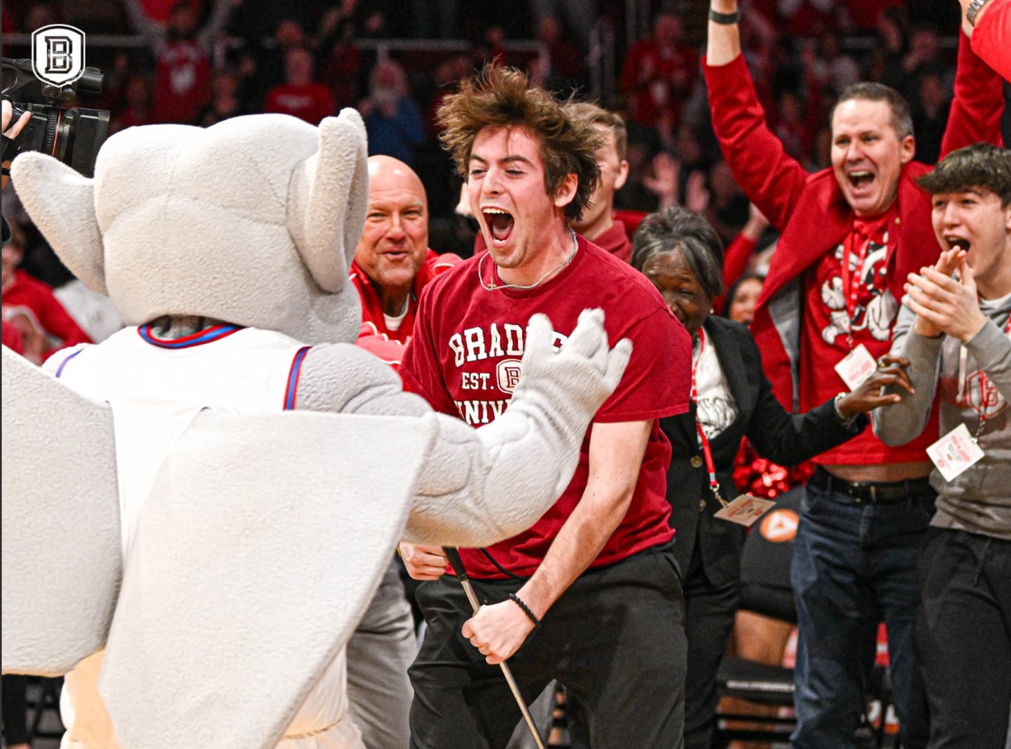Trevor Frey, a Bradley University freshman from Lake in the Hills, celebrates with the Bradley mascot Kaboom! after making a putt across the basketball court on March 2, 2025, to win a new car.
