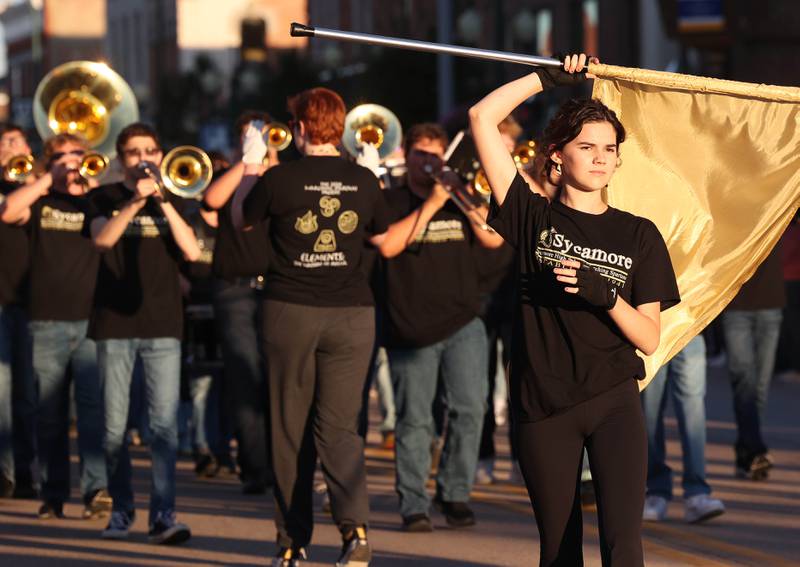 Members of the flag team and marching band make their way down State Street in Sycamore Wednesday, Sept. 25, 2024, during the Sycamore High School homecoming parade.