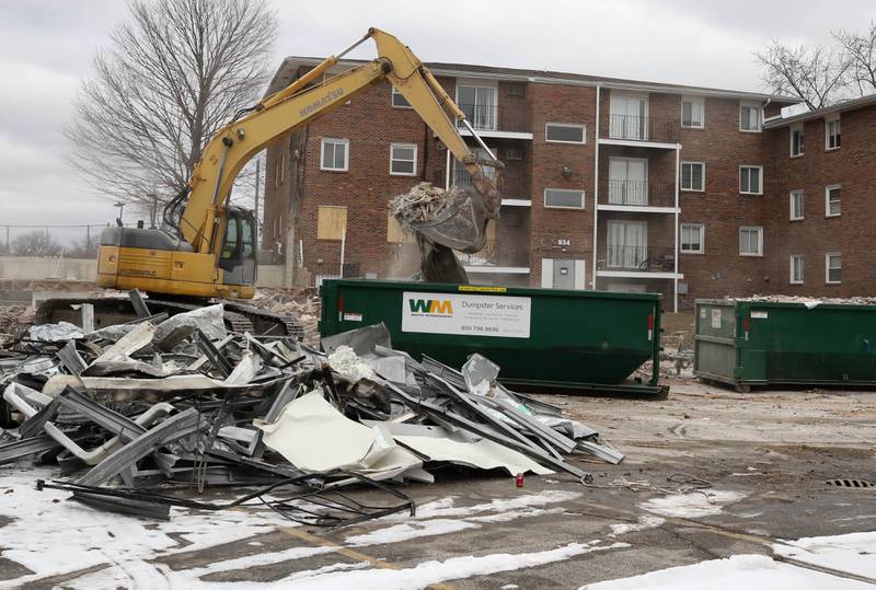 An excavator puts debris in a dumpster after a portion of the apartments at 1024 W. Hillcrest Drive in DeKalb was torn down earlier in the day. The structure was ravaged by fire on Dec. 22, 2024, and condemned.