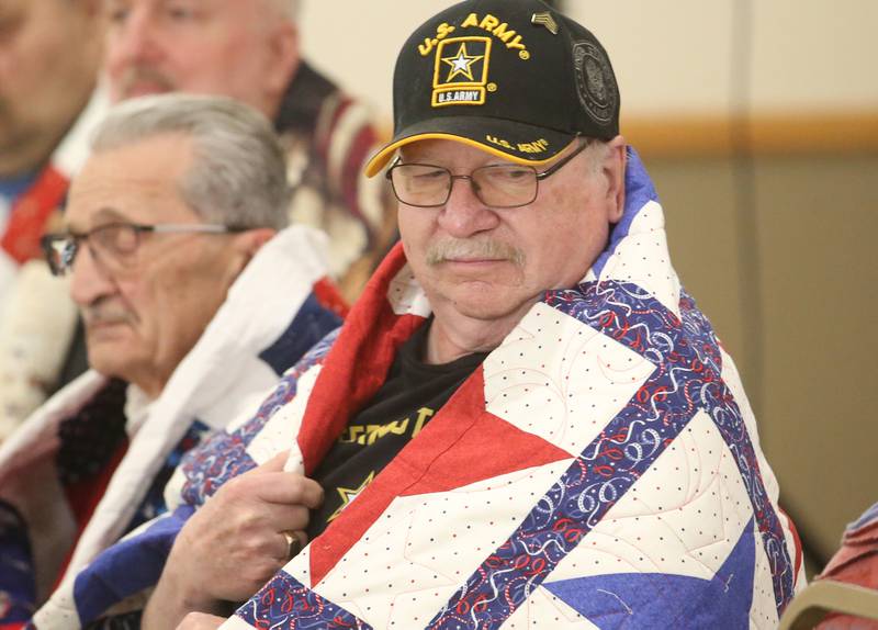 Veteran Robert Patarozzi, clenches his quilt during the Quilt of Valor ceremony on Saturday, April 19, 2025 at the Moose Lodge in Princeton.