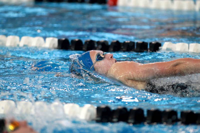 St. Charles North’s Jenna Williams competes in the 100-yard backstroke consolation heat during the IHSA Girls State Swimming and Diving Championships at the FMC Natatorium in Westmont on Saturday, Nov. 11, 2023.