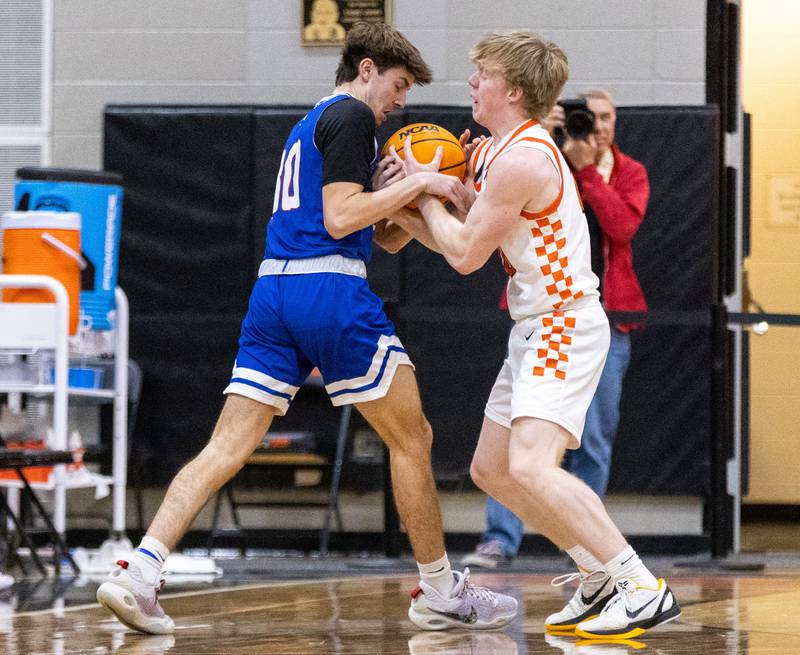 St. Charles East guard Gavin Sterling and Marmion Academy guard Matthew Murray wrestle over the ball during at St. Charles East High School on Saturday, Jan. 4, 2025.
