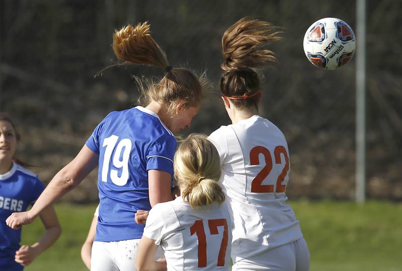 Dundee-Crown's Kate Raby, left, heads the ball over the defense of Crystal Lake Central's Olivia Anderson, center, and Shaylee Gough, right, for a goal during a Fox Valley Conference soccer match Tuesday April 26, 2022, between Crystal Lake Central and Dundee-Crown at Dundee-Crown High School.
