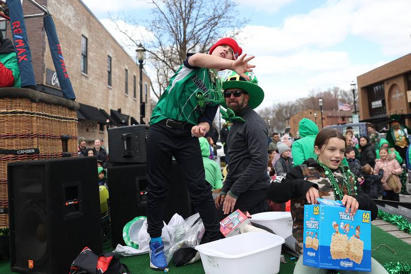 A kid throws candy to the crowd from the Re/Max float in the Plainfield Hometown Irish Parade on Sunday, March 17, 2024 in Plainfield.