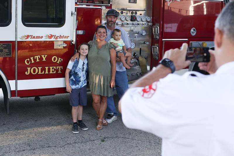 Fire battalion chief John Koch takes a photo of William Zaffino with his family in front of the fire truck. William won a raffle to get a ride in a fire truck to his first day of school at Eisenhower Academy in Joliet. Wednesday, Aug. 17, 2022, in Joliet.