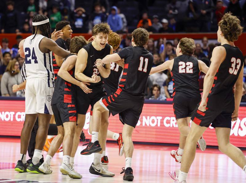 Benet’s Edvardas Stasys (23) is mobbed by teammates at the of the game against DePaul College Prep at the IHSA Class 4A boys basketball state semifinal Friday, March 13, 2026 at the State Farm Center in Champaign.