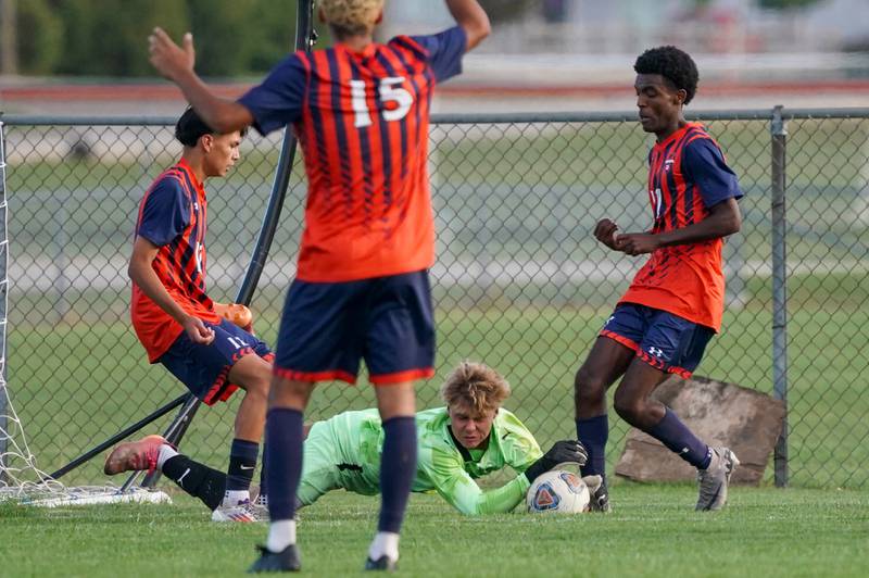 Oswego East's Jack Urbanowski (1) makes a diving save against Oswego during a soccer match at Oswego High School on Tuesday, Oct. 1, 2024.