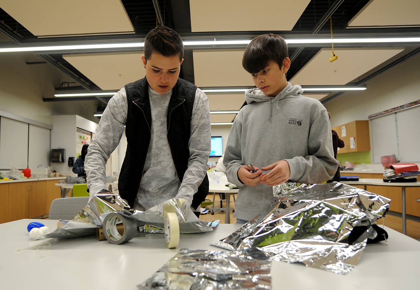 STEM teacher Bethany Bellavia talks with Prairie Grove Middle School seventh grader, Penn Bonham as he works on making a parachute during a Flight and Space STEM class at the school on Tuesday, April 26, 2022.