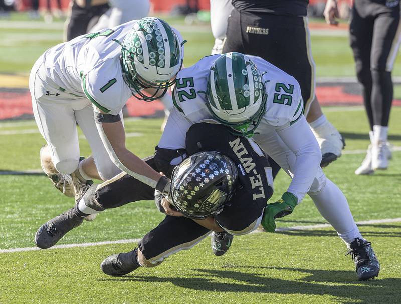 Lena-Winslow’s Alec Schlichting is hauled down by Brown County's Beau Little (left) and Vladimir Rebarcak Friday, Nov. 28, 2025, in the Class 1A football finals at Hancock Stadium at ISU.