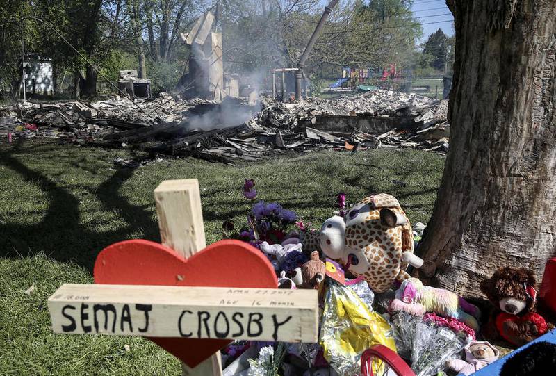 A memorial of salvaged mementos sits in front of a tree Saturday after a fire broke out at the former home of Sema'j Crosby in Joliet Township.