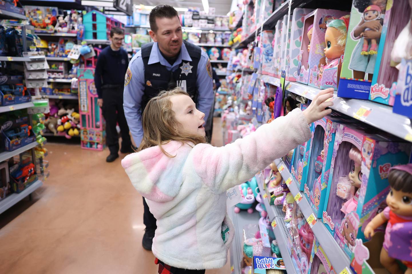 Vivian, 8, picks out a doll with Officer Mike Phad at the annual Santa Cop at Walmart in Joliet.
