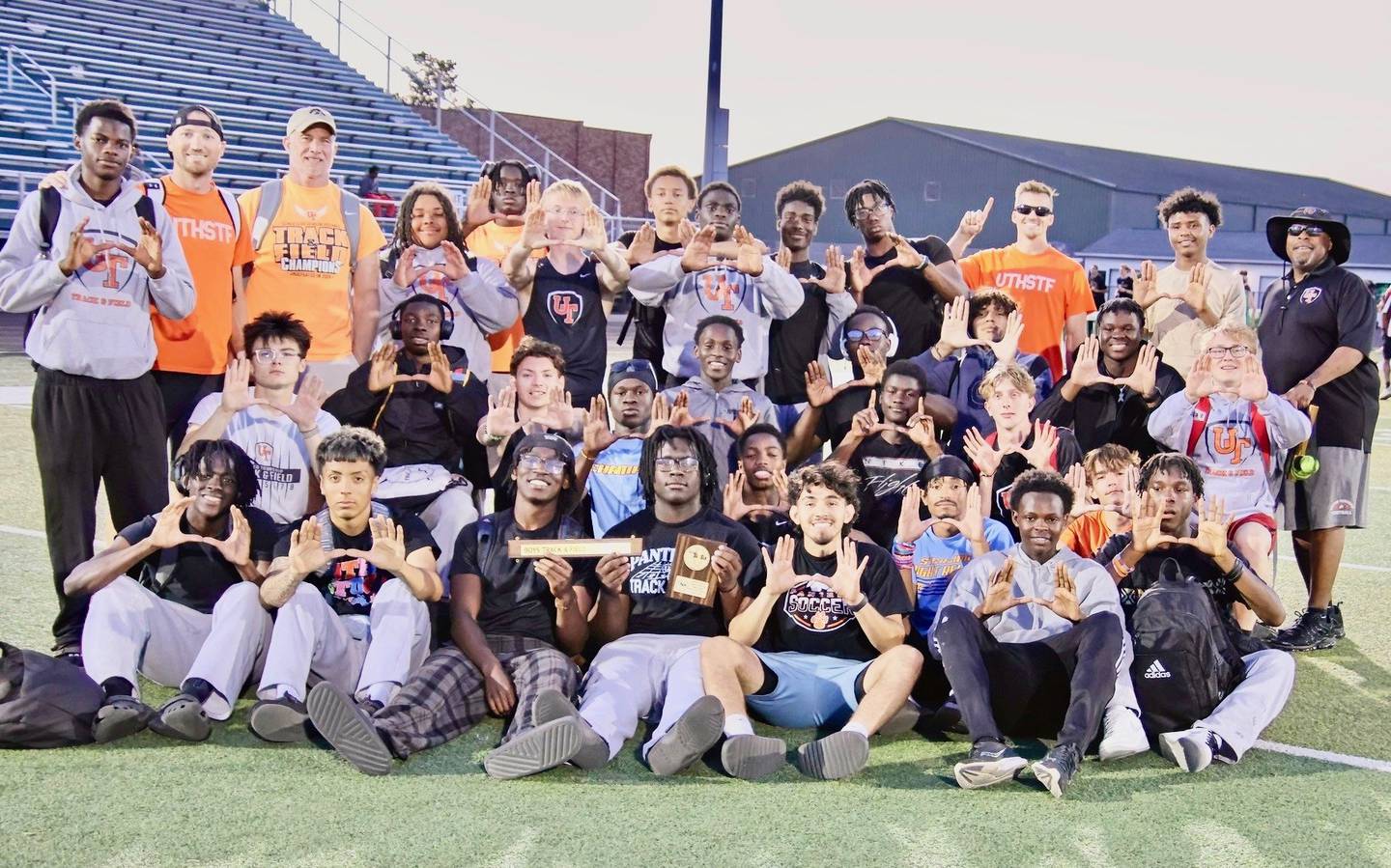 United Township head track coach Evan Holschbach (back row), a former Princeton state medalist, is used to winning when it comes to races. He's in the fight against ALS, which claimed his dad, Leon, in 2022, to win it.