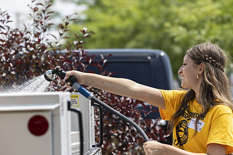 Newman BLIND leader Olivia Clark hoses down a truck Friday, August 4, 2023. The group will b3e undergoing some pretty intensive training on Saturday at New Life Lutheran Church.