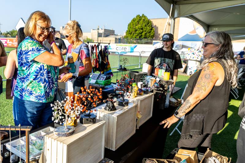 Anne Johnson, from David Nelson Jewelry, chats with Karen Moats at the Soul Journey Gems booth during New Orleans North Festival at Joliet Slammers Stadium on Aug. 15, 2025.