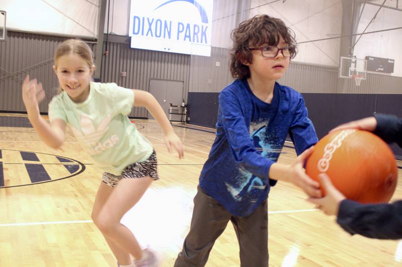 Cambree Penick races to the front of the line after passing a playground ball to Deacon Mortimer on Tuesday morning as part of a team relay game during the Winter Mini Spark day camp at The Facility in Dixon.