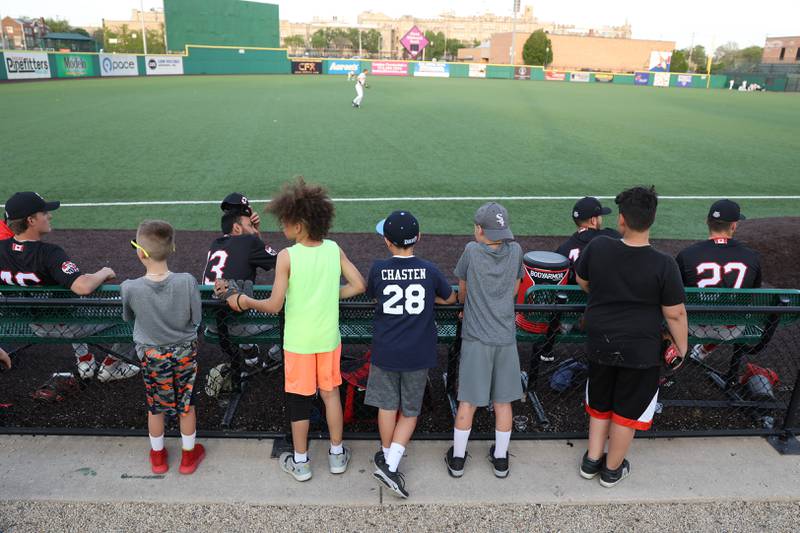 Kids huddle behind the Ottawa Titans bullpen on the Joliet Slammers at the home opener at DuPage Medical Group Field. Friday, May 13, 2022, in Joliet.