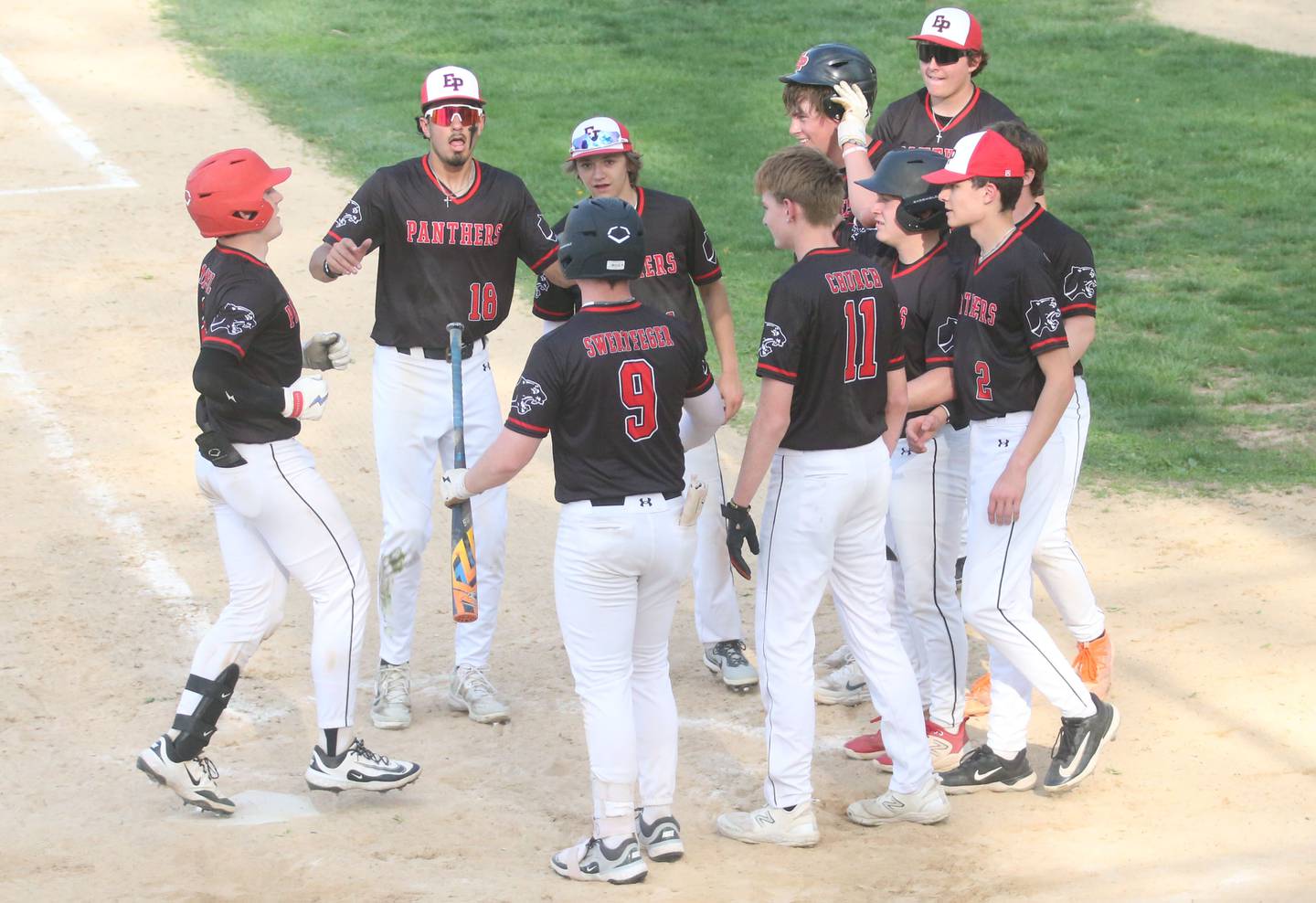 Erie-Prophetstown's Parker Rangel (left) steps on home plate after hitting a homerun against Hall on Monday, April 28, 2025 in Foley Field at Kirby Park in Spring Valley.