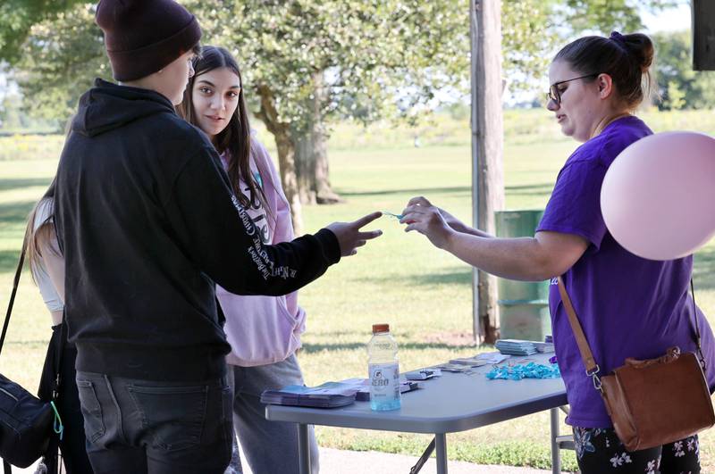 Beth Ganion, manager of prevention and communications for Safe Passage, hands out information Friday, Sept 15, 2023, at the Sycamore Community Sports Complex during celebration of the life of Gracie Sasso-Cleveland on what would have been her sweet 16 birthday. Sasso-Cleveland, 15, was found dead May 7, 2023, in DeKalb. Timothy M. Doll, 29, of DeKalb, is charged with first-degree murder in her death.
