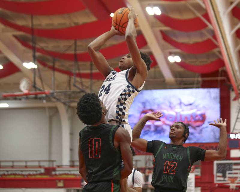 Oswego East's Dshaun Bolden (24) puts in a basket over the defense during their Hinsdale Central Holiday Classic basketball game between Morgan Park at Oswego East Saturday, Dec 27, 2025 in Hinsdale.
