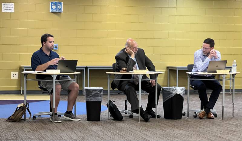 Michael DeVito talks during the July 18, 2023 Sycamore Community School District 427 Board of Education meeting as Board Chair Jim Dombek (middle) and Eric Jones (right) listen.