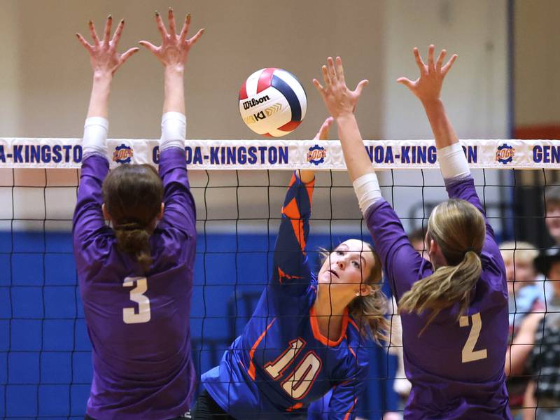 Genoa-Kingston's Bria Botterman spikes the ball between Rochelle's Kyrie Cragin (left) and Jaydin Dickey during their match Monday, Sept. 15, 2025, at Genoa-Kingston High School.