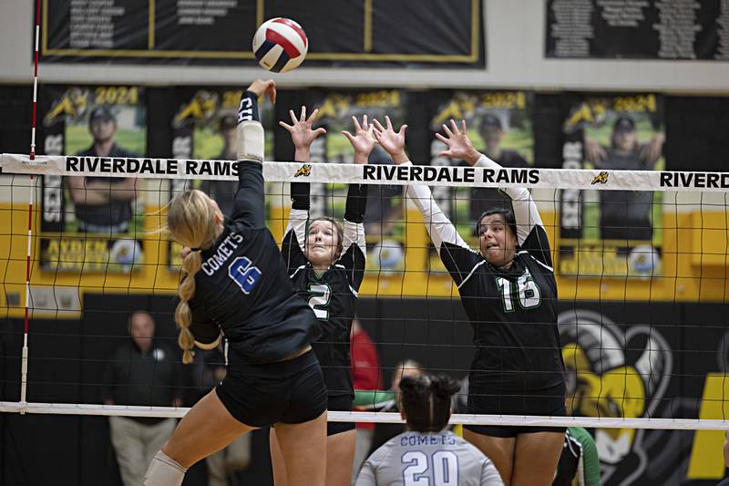 Newman’s Jess Johns spikes against Rock Falls’ Kacie Witherow (left) and Taylor Reyna Thursday, Oct. 26, 2023 in the class 2A regional finals at Riverdale.