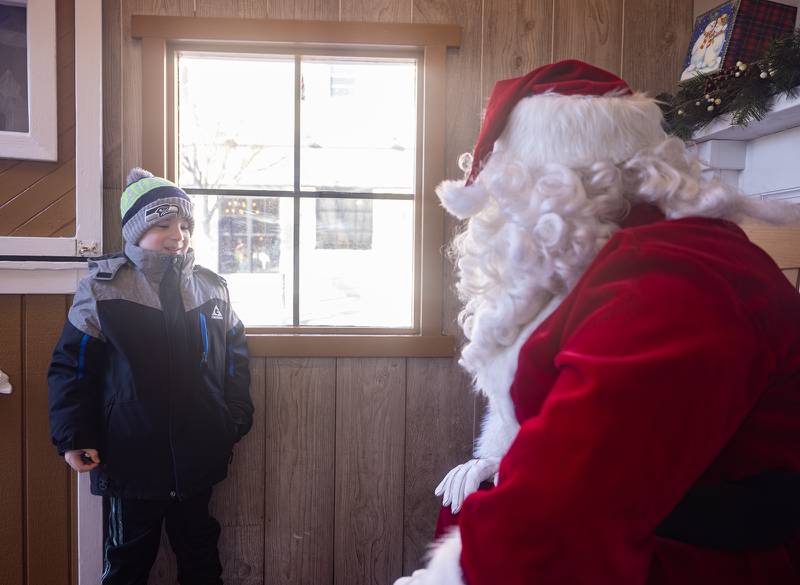 Bridger Mcewan, 6, of Hinsdale talks with Santa Claus at the Gingerbread House in Downers Grove, Ill. on Sunday, Dec. 18, 2022.