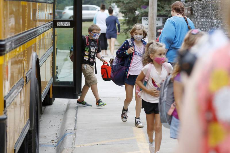 Students hop off the bus to be welcomed back to school by staff on their first day back at Landmark Elementary School on Wednesday, July 21, 2021, in McHenry.  The school, which has about 210 students, offers a shortened summer break but extended fall and winter breaks to make the educational process more year-round.