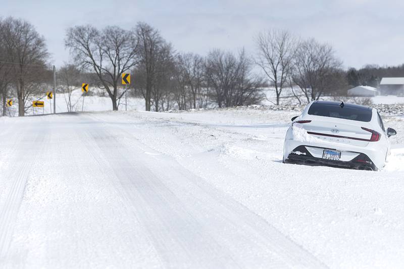 A car sits in a ditch on Rock Island Road in Dixon on Monday, March 16, 2026, a victim of drifting snow along this rural route.
