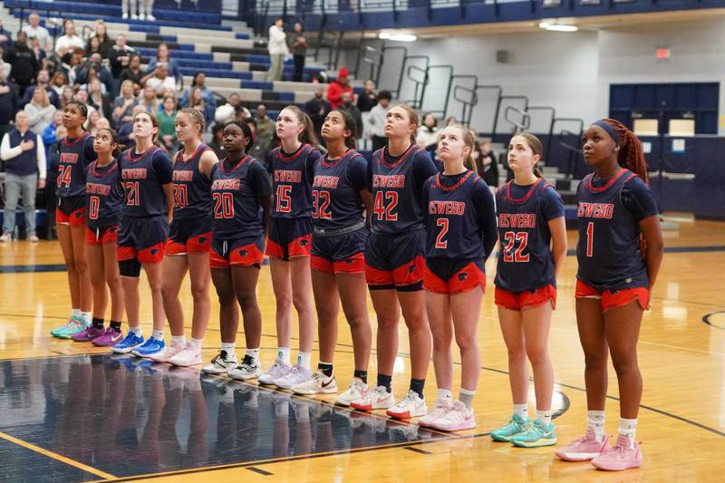 Oswego players line up for the National Anthem during a basketball game against Oswego East at Oswego East High School on Saturday, January 14, 2017.