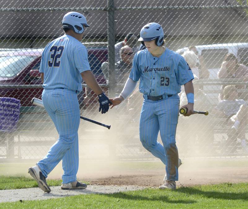 Marquette’s Sam Mitre congratulates Grant Dose as he crosses the plate to score against Seneca Tuesday at Marquette.