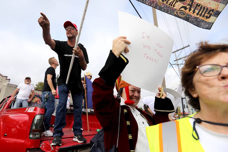 A Trump supporter yells as he counter protests from the bed of a pickup truck during a "No Kings” protest rally on Saturday, Oct. 18, 2025, along Route 31 in McHenry. The protest drew thousands of protesters to the area to protest the policies of President Donald Trump.