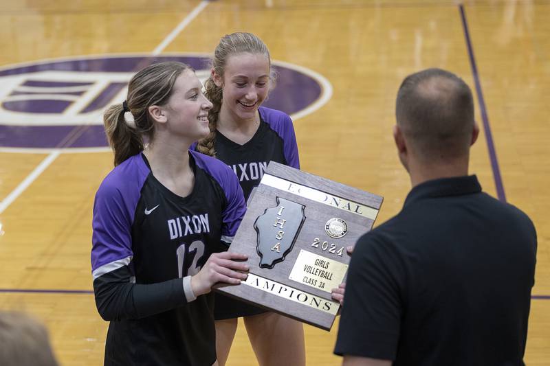 Dixon’s Isabelle Quackboerner and Leah Carlson take the plaque after winning the regional Thursday, Oct. 31, 2024 in the class 3A regional championship at Dixon High School.
