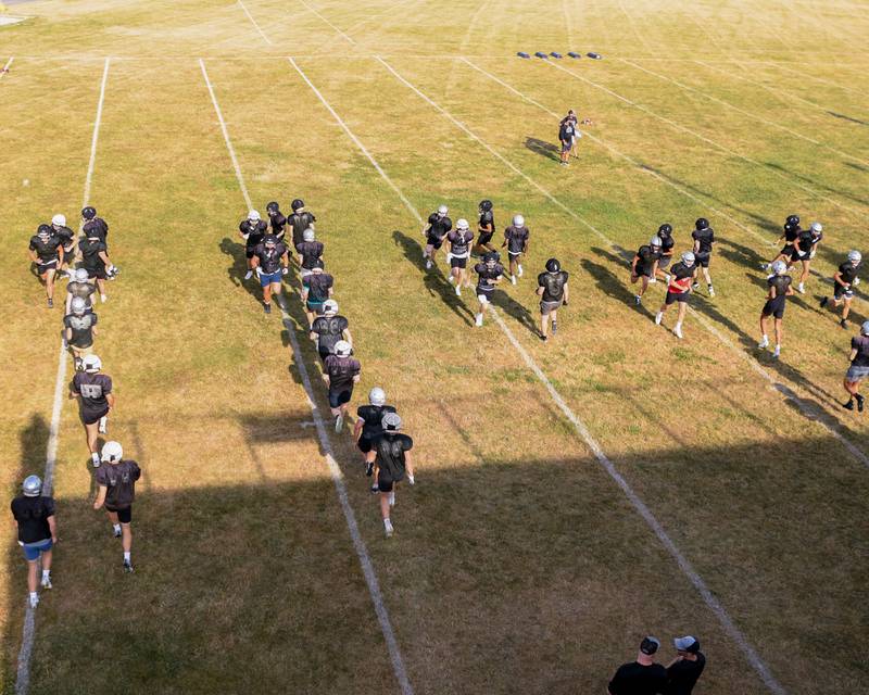 Kaneland football team warm up before a joint practice with Oswego High School on Thursday July 10, 2025, held at Oswego High School.