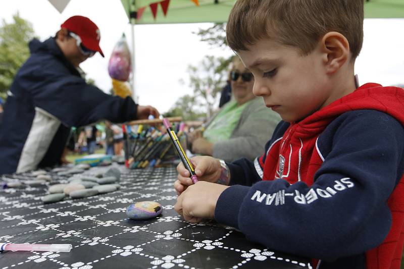 Henry Liddle, 4 paints a rock during the Ice Cream Fest on Friday, Aug. 9, 2024, at Crystal Lake’s Main Beach.  The second annual event featured music, ice cream venders and an ice cream eating contest.