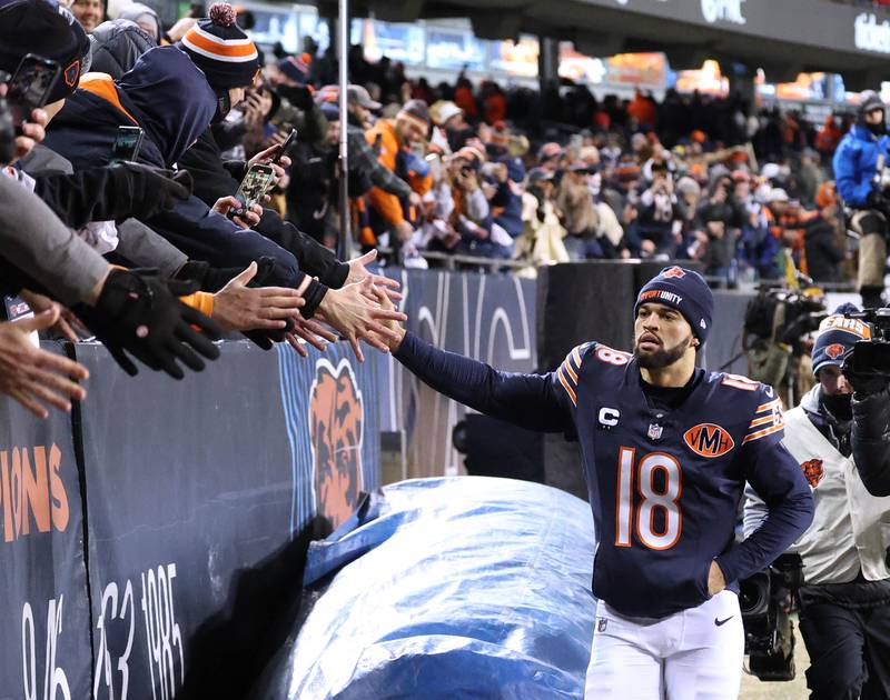 Chicago Bears quarterback Caleb Williams makes a loop around the stadium slapping hands with fans to celebrate after their 22-16 overtime win over the Green Bay Packers Saturday, December 20, 2025, at Soldier Field in Chicago.