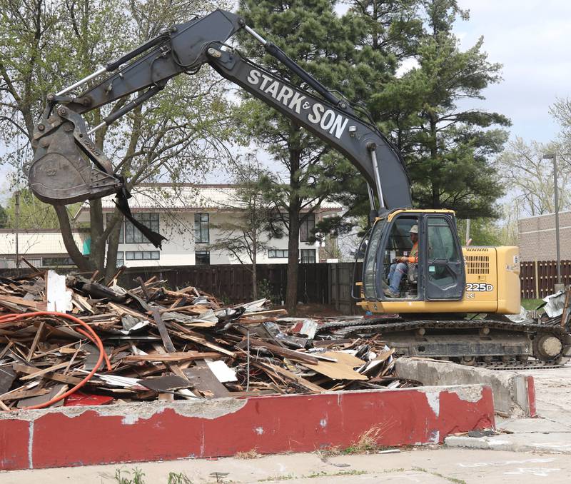 An excavator from Stark & Son clears debris Monday, April 28, 2025, after the former Illini Tire Co. building on the northeast corner West Lincoln Highway and Annie Glidden Road was torn down.