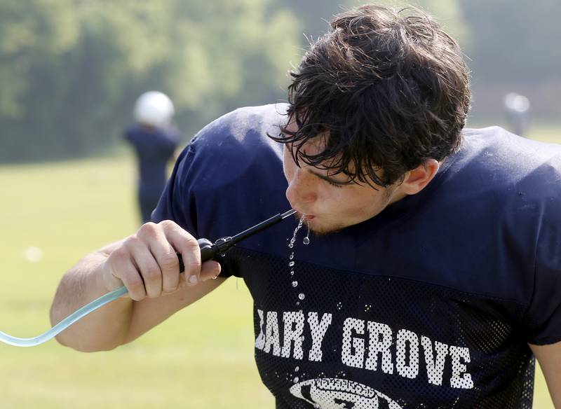 Cary-Grove’s Logan Abrams gets a drink of water during football practice Thursday, June 29, 2022, at Cary-Grove High School in Cary.