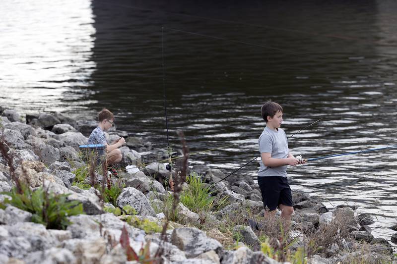 Owen Dempsey (left), 12, of Dixon and Huddson Long, 12, Mt. Morris try their luck Saturday, Sept. 20, 2025, during the 19th annual Cops and Bobbers fishing event in Dixon. The Dixon Police Department hosts the event as a way to encourage kids to get outside and have fun fishing.