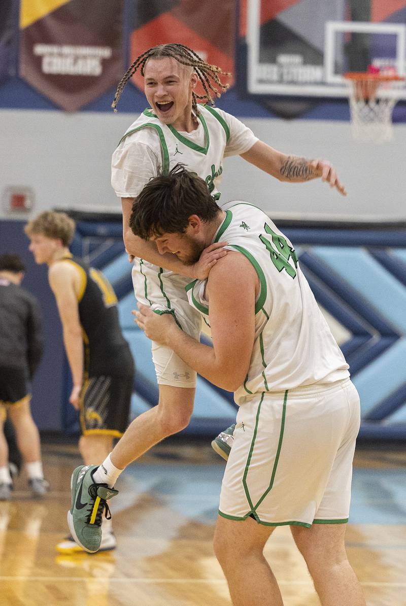 Rock Falls’ Nehemiah Menendez is hoisted by teammate  Garret Wolf after the Rockets’ OT win against Riverdale Friday, Feb. 28, 2025, during the Class 2A Regional final at Bureau Valley High School.